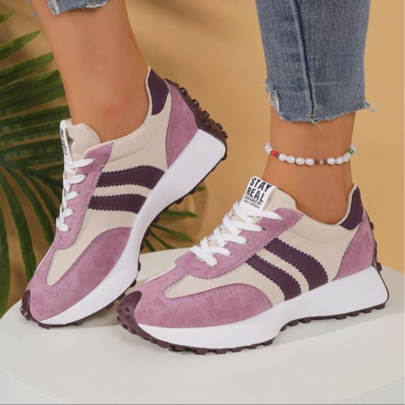 Flieder-beige Sneaker mit dunkelvioletten Streifen und weißer Plateausohle, getragen auf einem Podest, Seitenansicht 12