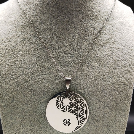 Yin-Yang-Anhänger aus Edelstahl mit filigranem Muster auf silberner Kette, Schmuckdisplay.