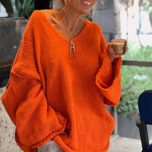 Frau in orangefarbenem Strickpullover hält Tasse Kaffee, lässige Herbstmode.