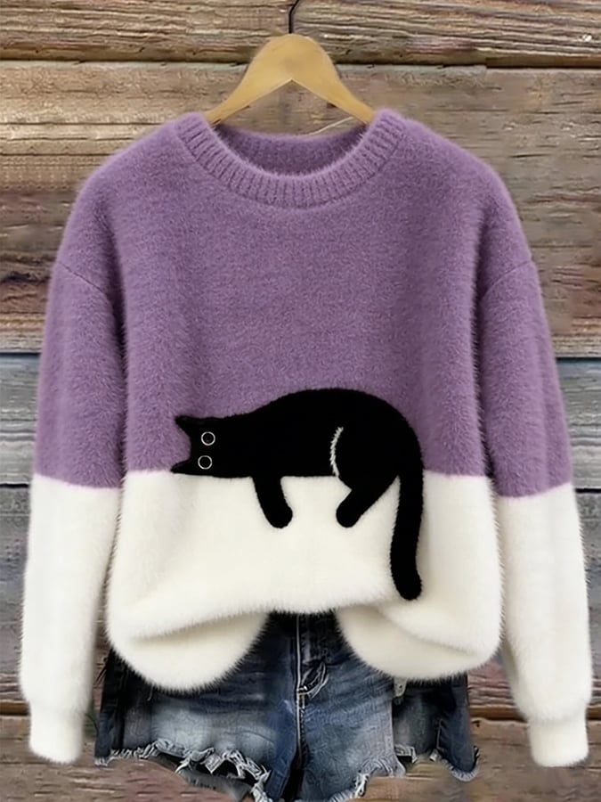 Flauschiger Pullover in Lila und Weiß mit schwarzer Katze, am Holzbügel vor Jeansshorts 10