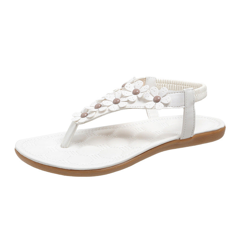 Weiße Damensandale mit Blumenverzierung, flache Sohle, Sommermode, bequemes Design.