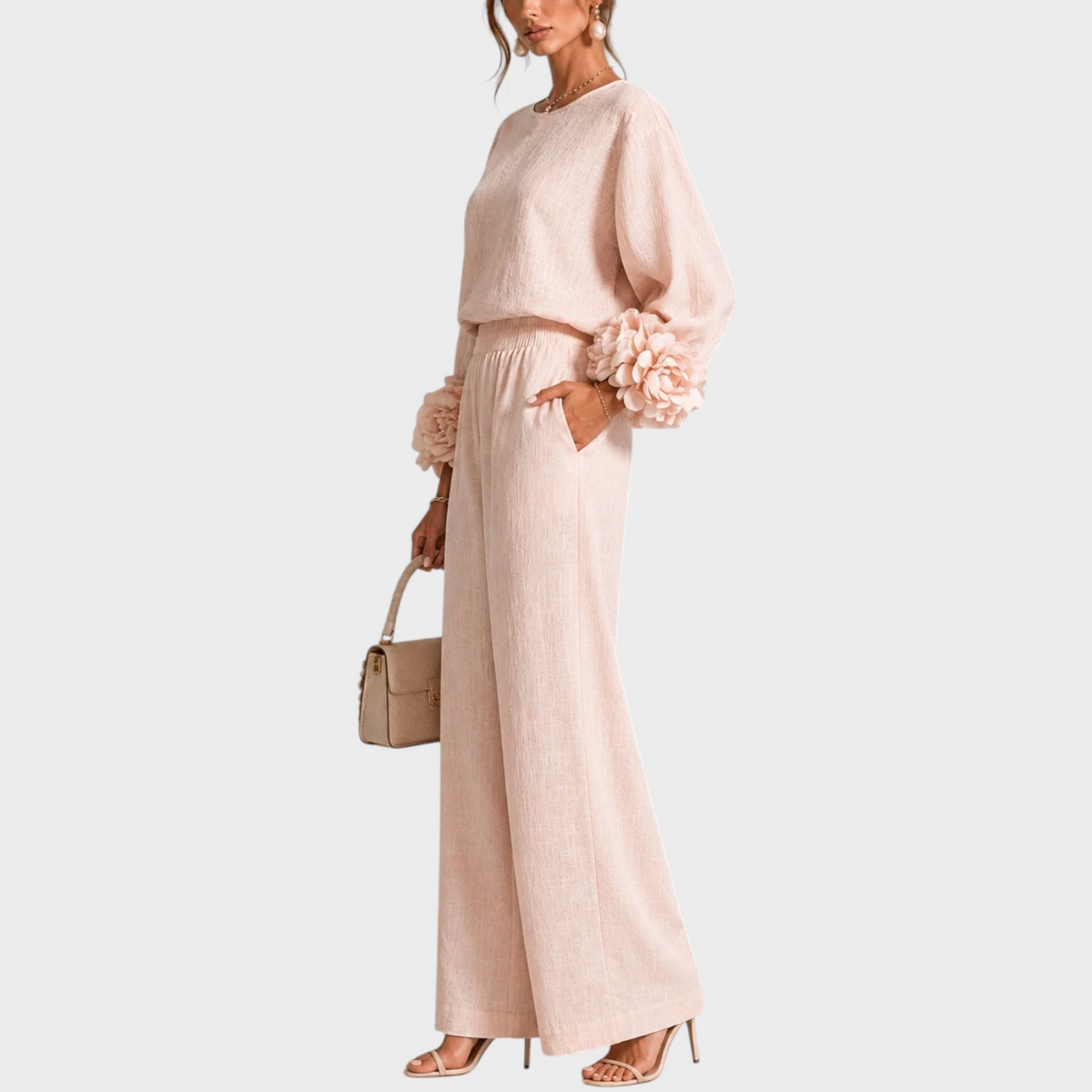 Seitenansicht in Rosé: Model mit Hand in der Hosentasche, Blütenmanschetten und beiger Handtasche 9