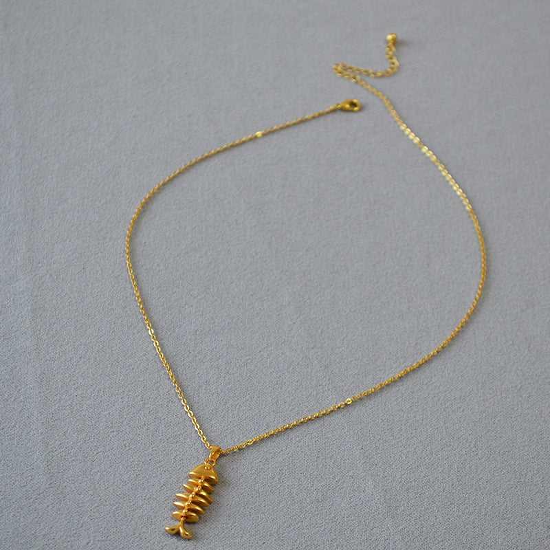 Goldene Halskette mit Fischgrätenanhänger, elegantes Schmuckstück, modisches Accessoire.