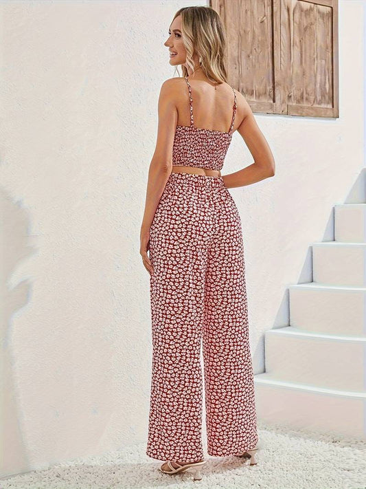 Frau in rotem Blumen-Zweiteiler, Sommermode, ärmelloses Top, weite Hose, helle Sandalen.