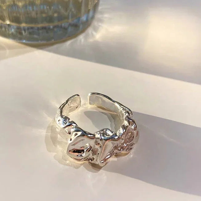 Silberner, verstellbarer Ring mit organischem Design auf weißem Hintergrund, Schmuckaccessoire.