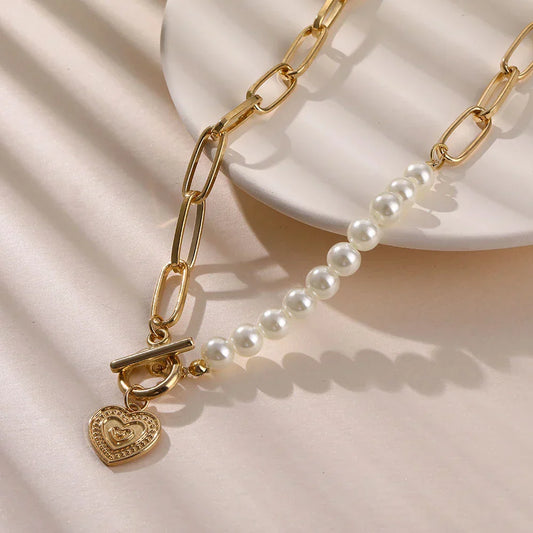 Goldene Halskette mit Herzanhänger und Perlen, modisches Schmuckstück für Damen.