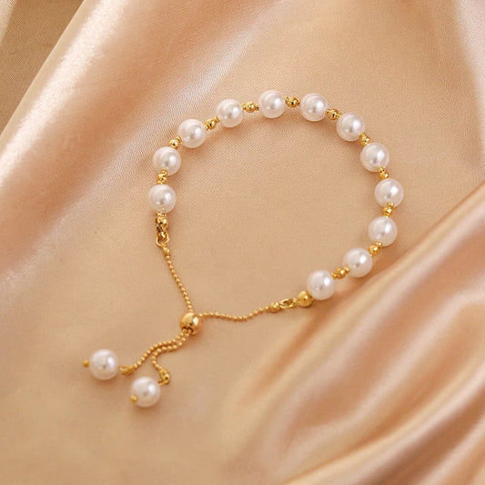 Perlenarmband mit goldenen Akzenten auf beigem Satin, eleganter Schmuck, verstellbar.