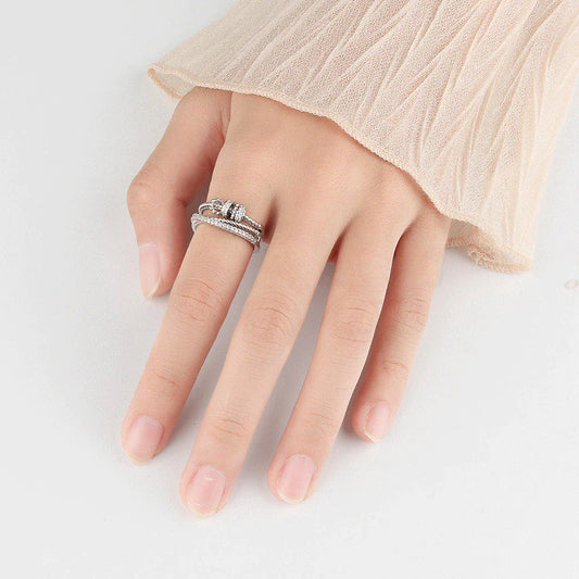 Damenhand mit silbernem Diamantring-Set, elegantes Schmuckdesign, Nahaufnahme.
