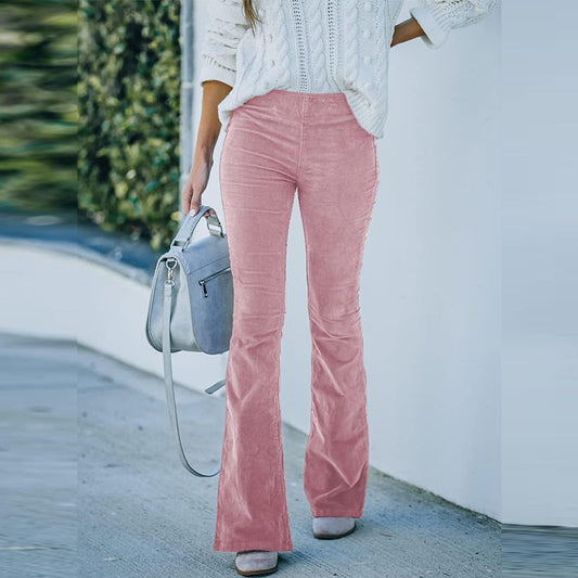 Frau in rosa Cordhose und weißem Strickpullover, hält graue Handtasche.