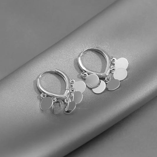 Silberne Creolen Ohrringe mit runden Anhängern, eleganter Schmuck für Damen.