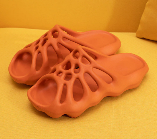 Orange 3D-gedruckte Sandalen, atmungsaktiv, rutschfest, modisch, auf gelbem Hintergrund.