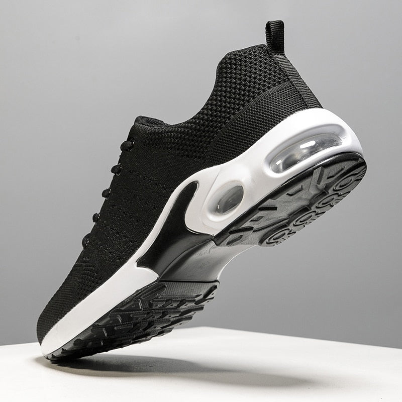 Schwarzer Sportschuh mit weißer Sohle, atmungsaktives Mesh, Herren Sneaker, seitliche Ansicht.