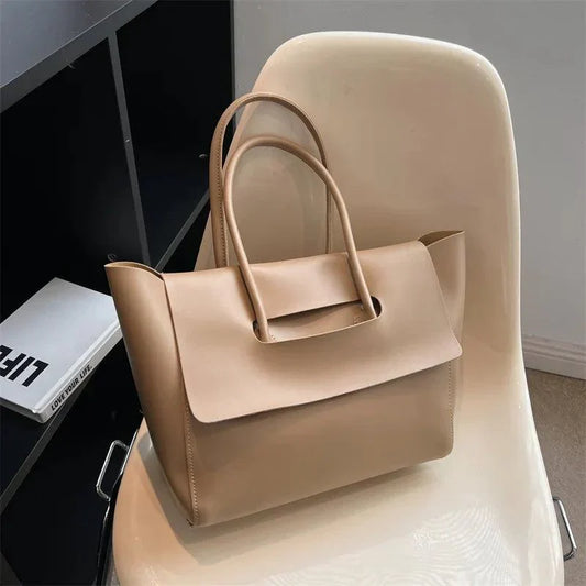 Beige Lederhandtasche auf Stuhl, elegantes Design, Damenmode, geräumig, stilvoll, modern.