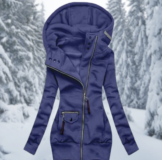 Blauer Damenmantel mit Kapuze, Reißverschluss, Wintermode, vor verschneitem Waldhintergrund.
