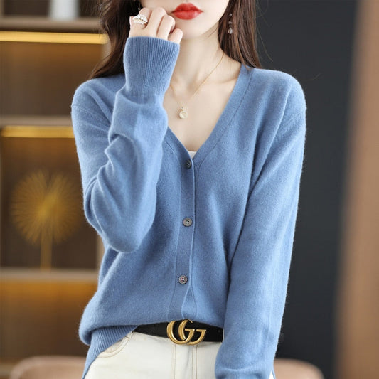 Frau trägt blauen Kaschmir-Cardigan, V-Ausschnitt, Knöpfe, elegantes Design, modisch.