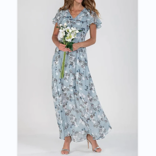 Frau in hellblauem Blumenkleid mit Blumenstrauß, elegantes Sommeroutfit, V-Ausschnitt, Rüschen.
