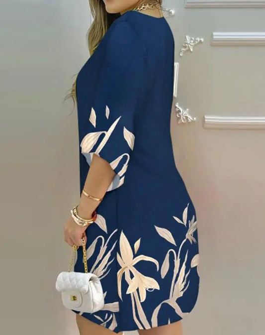 Damenkleid blau mit Blumenmuster, 3/4-Ärmel, elegante Mode, Handtasche, Rückansicht.