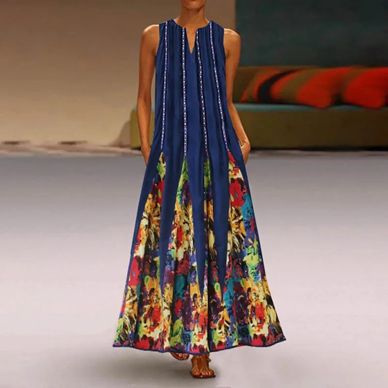 Frau in langem, ärmellosem, blauem Kleid mit buntem Blumenmuster, Sommermode, elegant.