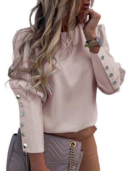 Frau in rosa Bluse mit Knöpfen, blonde Haare, hält graue Handtasche, modisch, elegant.