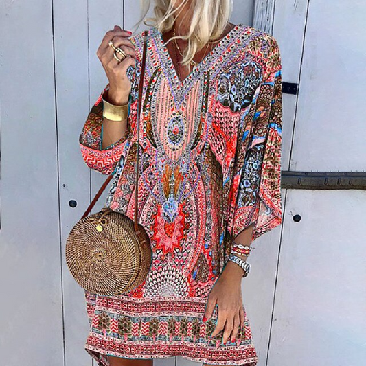 Frau in bunter Boho-Minikleid mit langen Ärmeln, runde Strohtasche, modisch, lässig.
