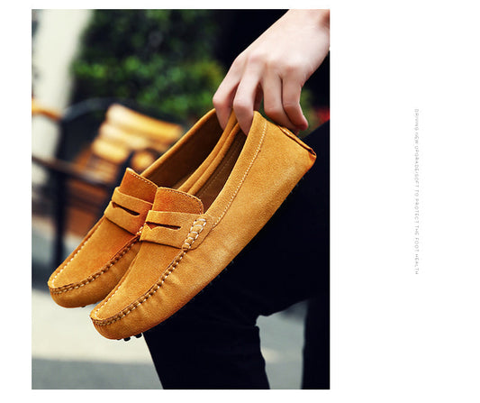 Hand hält braune Wildleder-Mokassins, bequeme Freizeitschuhe für Herren, stilvoll und modern.