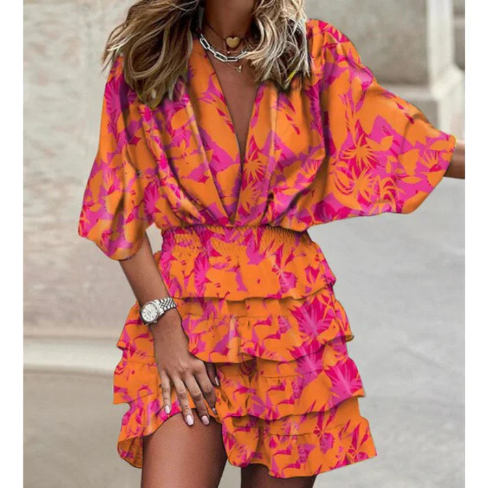 Frau in orange-pinkem Blumenkleid mit Rüschen, Sommermode, elegantes Design, Straße.