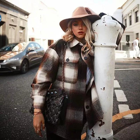Frau in karierter, brauner Übergangsjacke und Hut, Streetwear-Look, Frühling, Stadtstraße.