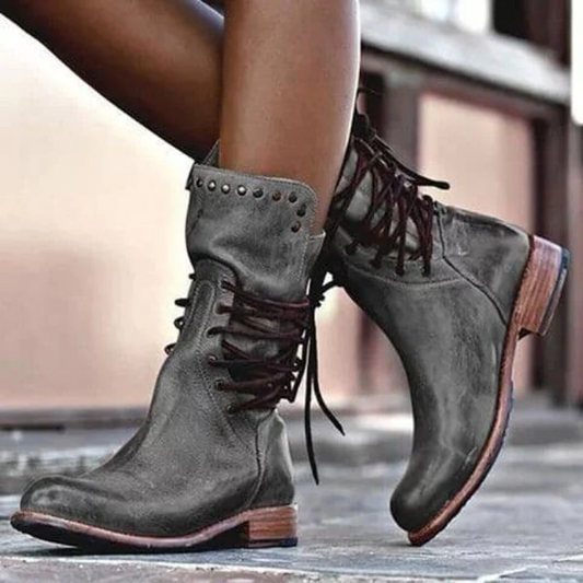 Damenstiefel aus grauem Leder mit Schnürung und Nieten, modisch und robust.