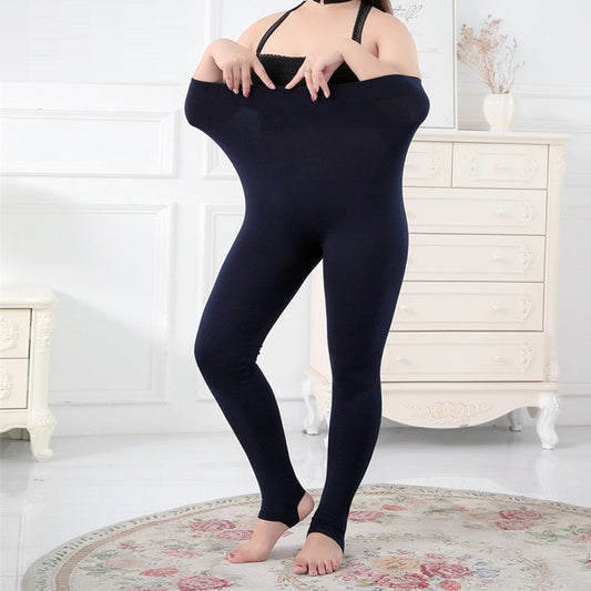 Frau in übergroßer, dunkelblauer Leggings im Wohnzimmer, weiße Kommode im Hintergrund.