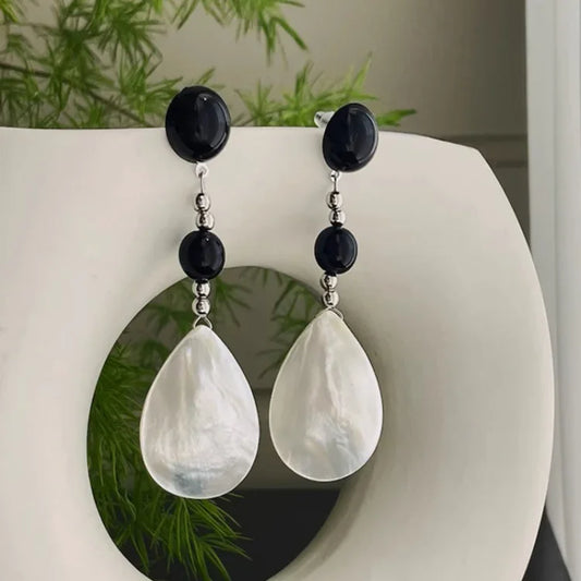Schwarze und weiße Perlenohrringe mit Tropfenanhänger, eleganter Schmuck, Damenaccessoire.