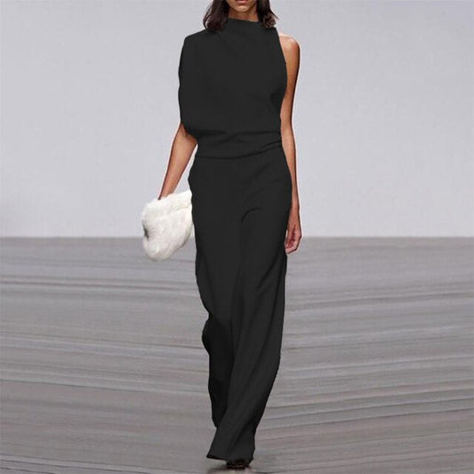Frau in schwarzem, ärmellosem Jumpsuit mit weitem Bein, hält weiße Clutch, elegantes Design.