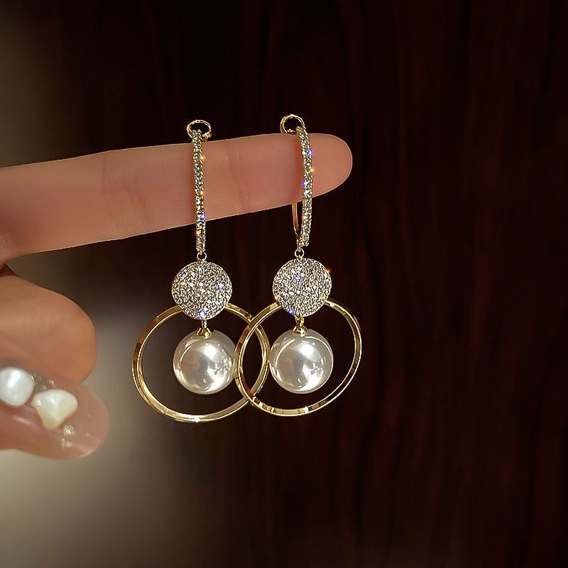 Goldene Ohrringe mit Perlen und Strass, elegantes Design, Schmuck für Damen, modisch.
