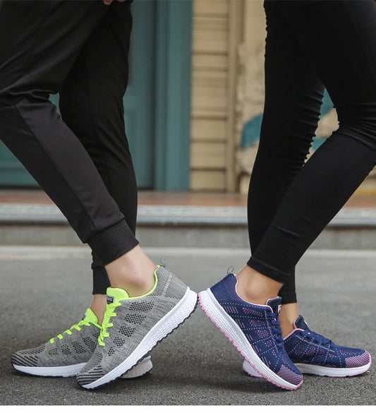 Zwei Paar Sportschuhe, grau und blau, auf Asphalt getragen, ideal für Laufen und Fitness.