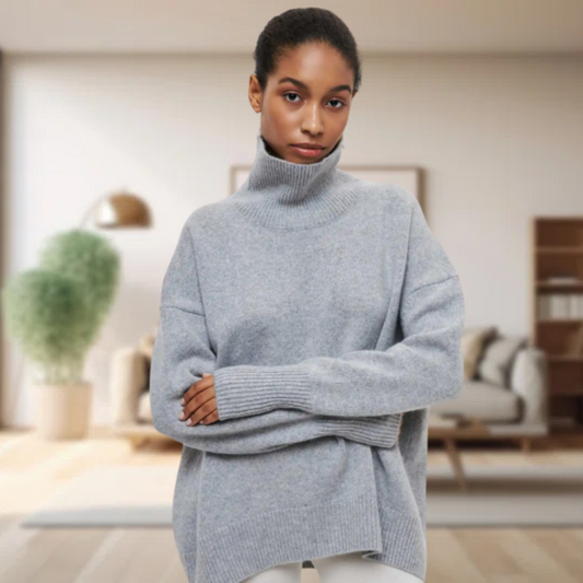 Frau in grauem Rollkragenpullover aus Wolle, gemütliches Wohnzimmer, moderne Einrichtung.