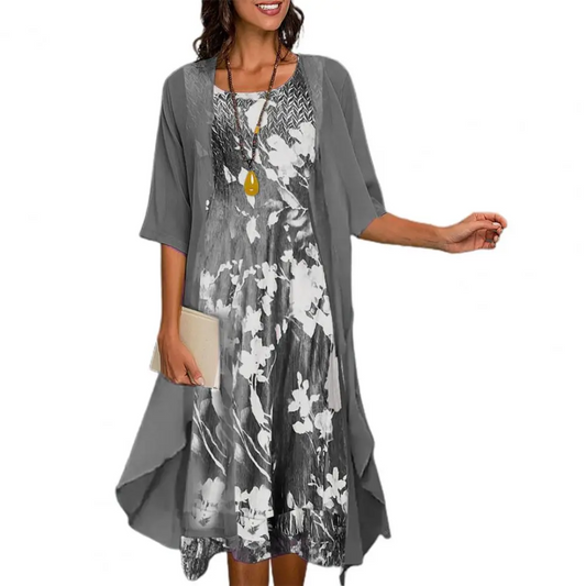 Frau in grauem, geblümtem Sommerkleid mit Kette und Clutch, modisches Damenoutfit.