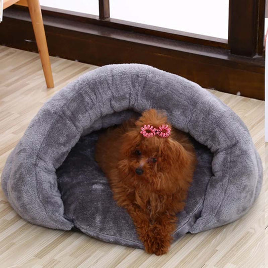 Kleiner Hund in grauem, plüschigem Hundebett, gemütlich und warm, ideal für Haustiere.
