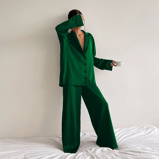 Frau in grünem Satinanzug mit Tasse, elegantes Outfit, modische Damenbekleidung.