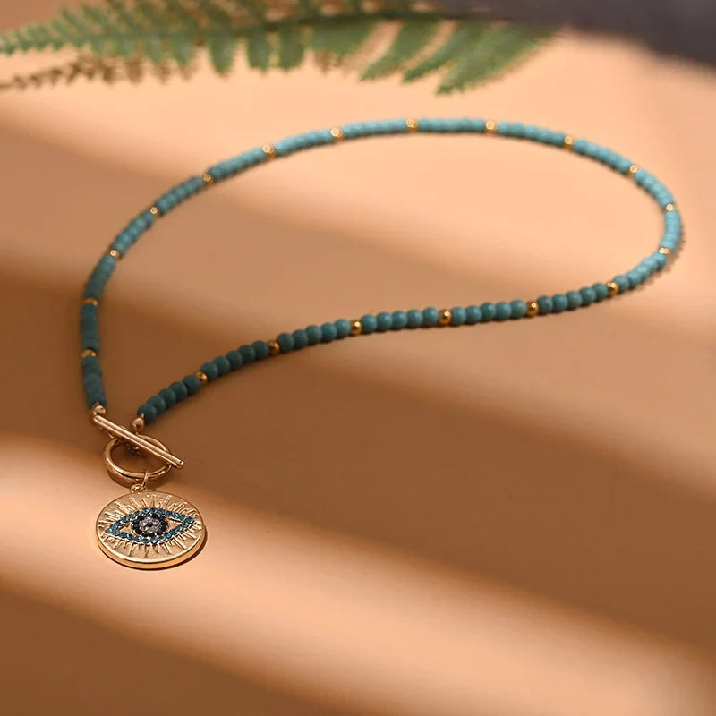 Türkisfarbene Perlenkette mit goldfarbenem Anhänger, Auge-Design, modisches Schmuckstück.