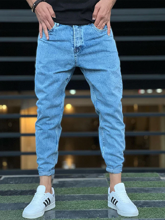 Mann trägt blaue Jeans und weiße Sneakers, lässige Mode, Streetwear, Herrenbekleidung.