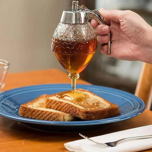 Hand gießt Honig aus Spender auf Toast auf blauem Teller, Frühstück, Küche, Honigspender.