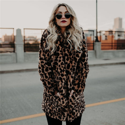 Frau in Leopardenmantel, Sonnenbrille, blonde Haare, urbaner Hintergrund, modischer Winterlook.