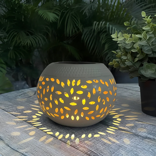 Keramik Windlicht mit Blattmuster, beleuchtet, auf Holztisch, Garten-Dekoration.