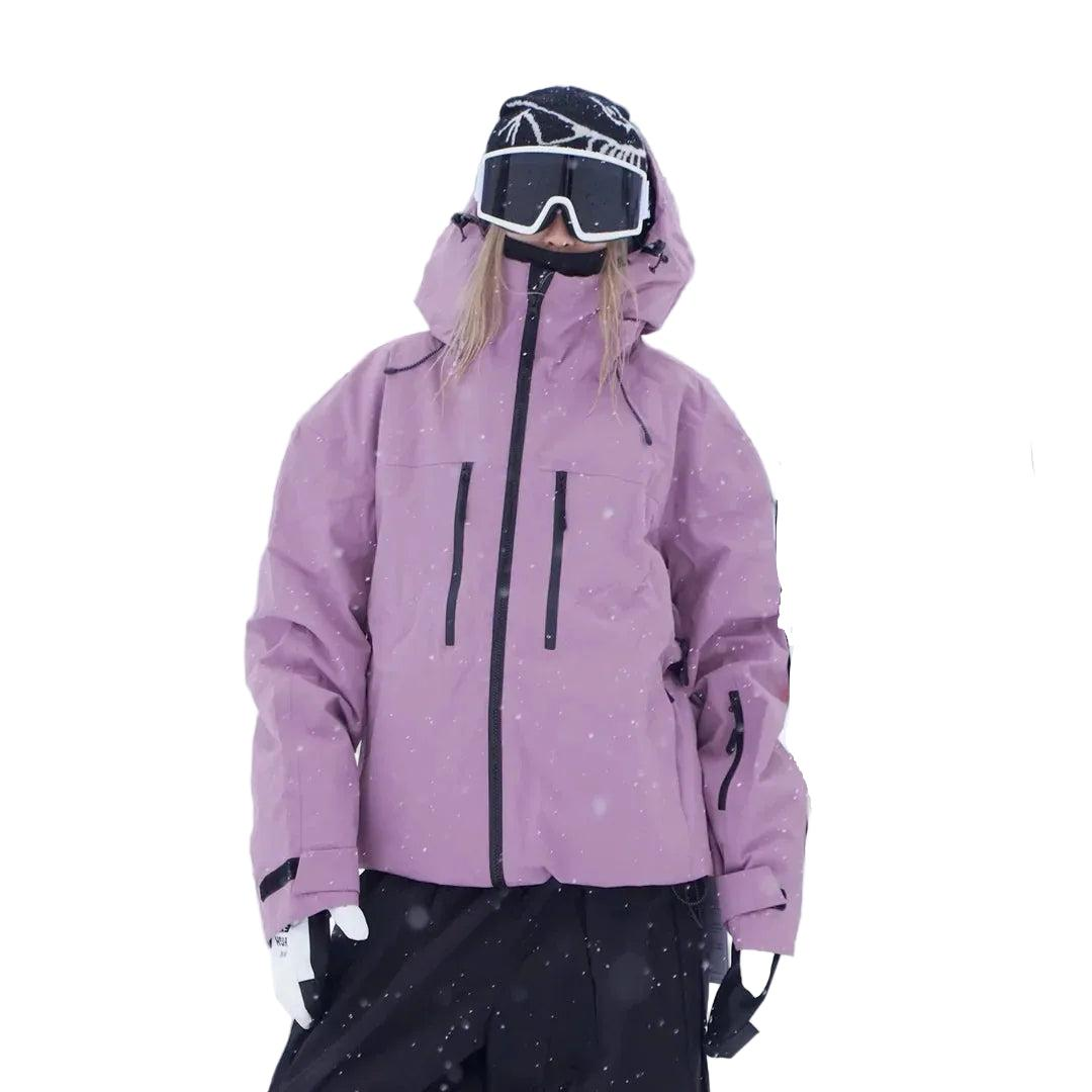Frau in rosa-violetter Schneejacke mit Kapuze, Skibrille und weißen Handschuhen, Frontansicht mit Brusttaschen, Ärmeltasche und Klettverschluss an den Ärmelbünd 4