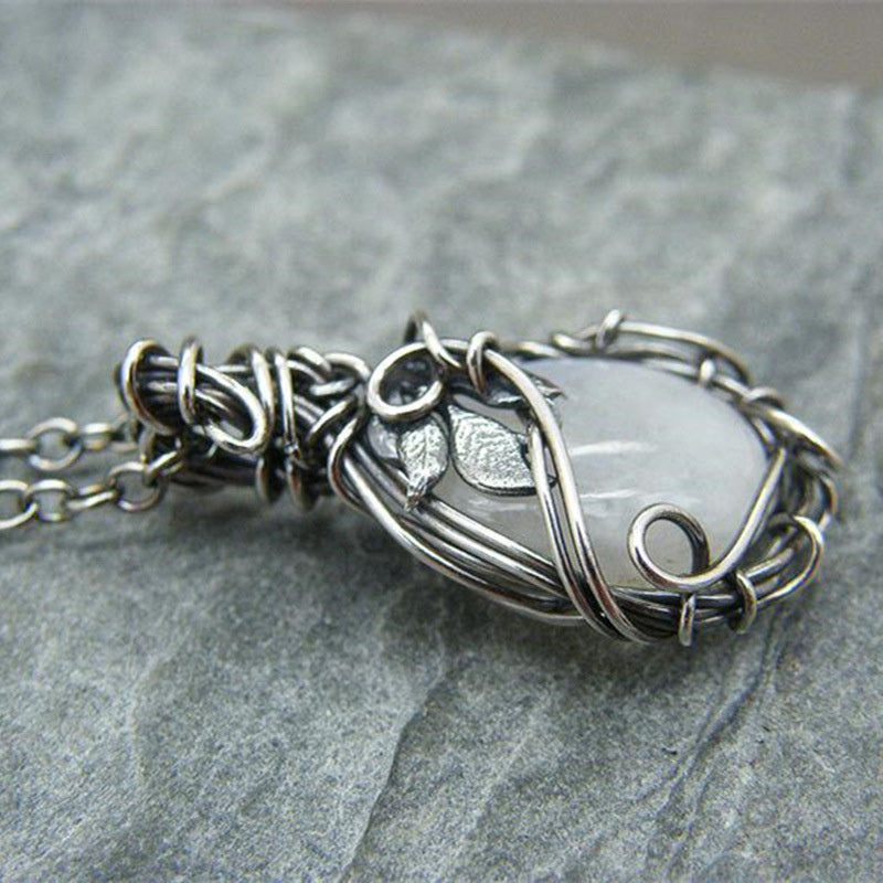Silberne Drahtkette mit weißem Edelsteinanhänger, handgefertigter Schmuck, elegantes Design.