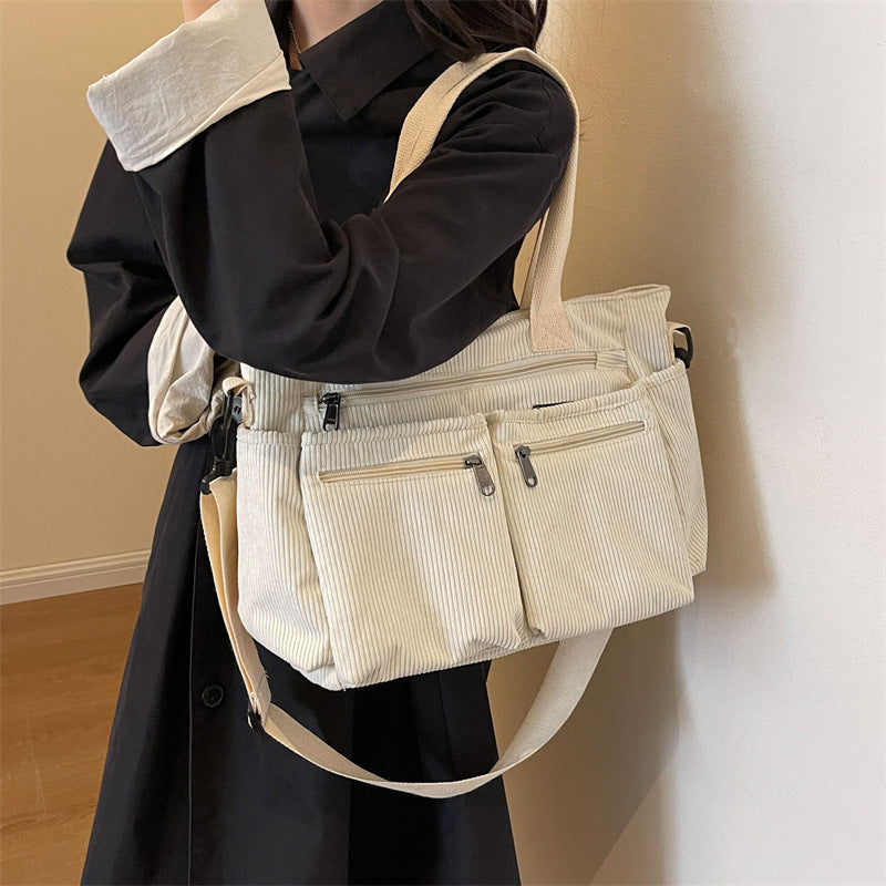 Frau mit weißer Cord-Umhängetasche, mehrere Taschen, modisch, praktisch, Damenmode.