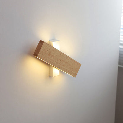 Querliegende Holzleiste vor weißem Wandarm, LED-Licht scheint oben und unten an die helle Wand. 9