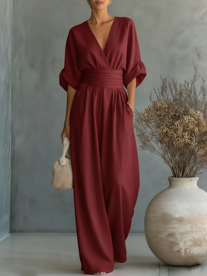 Weinroter Jumpsuit am Model, Ganzkörperansicht mit tiefem V-Ausschnitt und fließend weitem Hosenbein 9