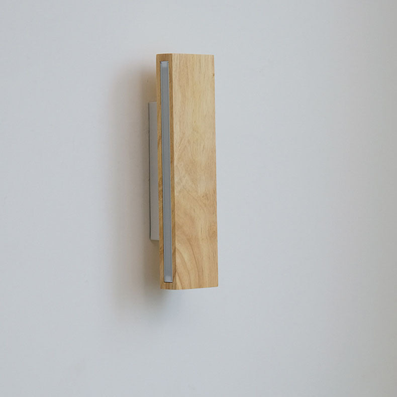 Ausgeschaltete Lampe mit senkrechter Holzleiste und milchigem Diffusor an der Seite, weiße Halterung dahinter. 11