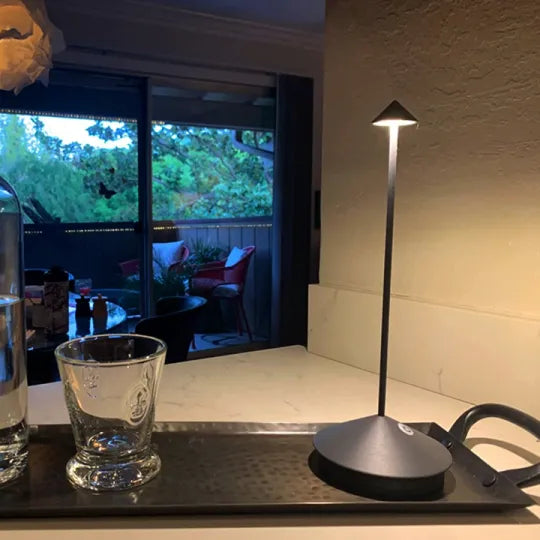 Moderne schwarze LED-Tischlampe auf Küchentheke, stilvolle Beleuchtung, Innenraum.