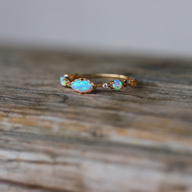 Opalring aus Gold mit Diamanten, eleganter Schmuck, handgefertigt, auf Holzoberfläche.